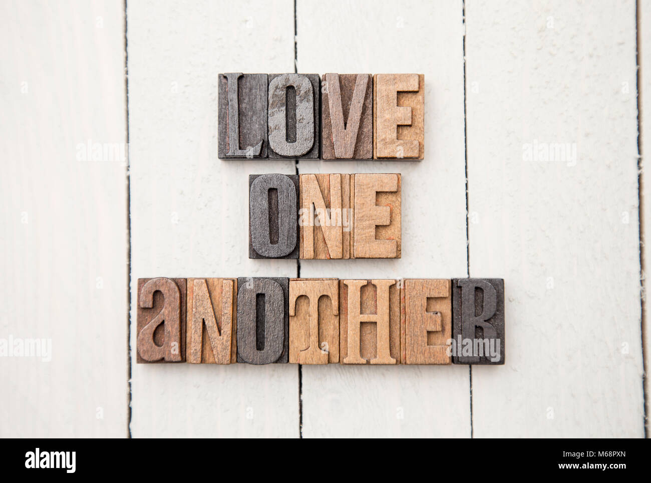 "Amatevi gli uni gli altri" scritto nel tipo impostato Foto Stock