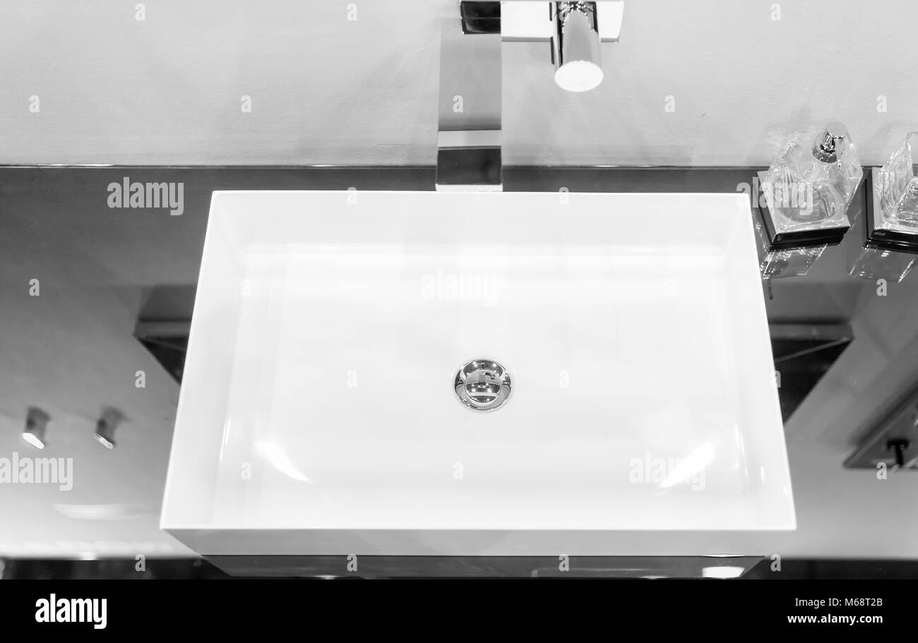 Piazza moderna lavandino montata in una superficie a specchio vicino a contenitori in vetro per sapone. Concetto di arredamento Foto Stock