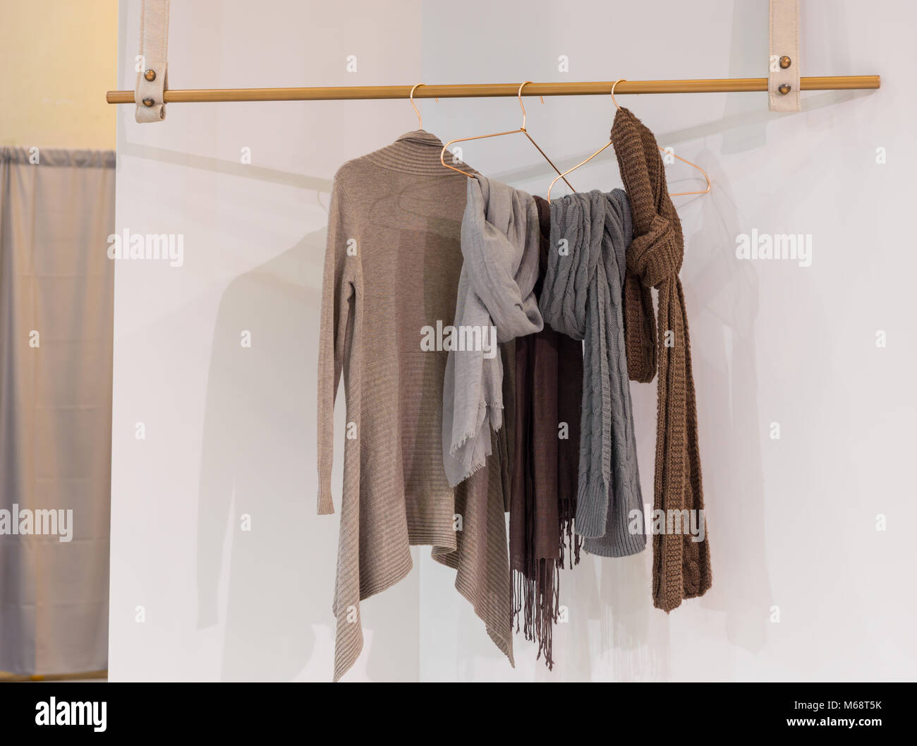 Moderno e accogliente armadio con vestiti appesi su appendiabiti in legno. Concetto di design interno Foto Stock