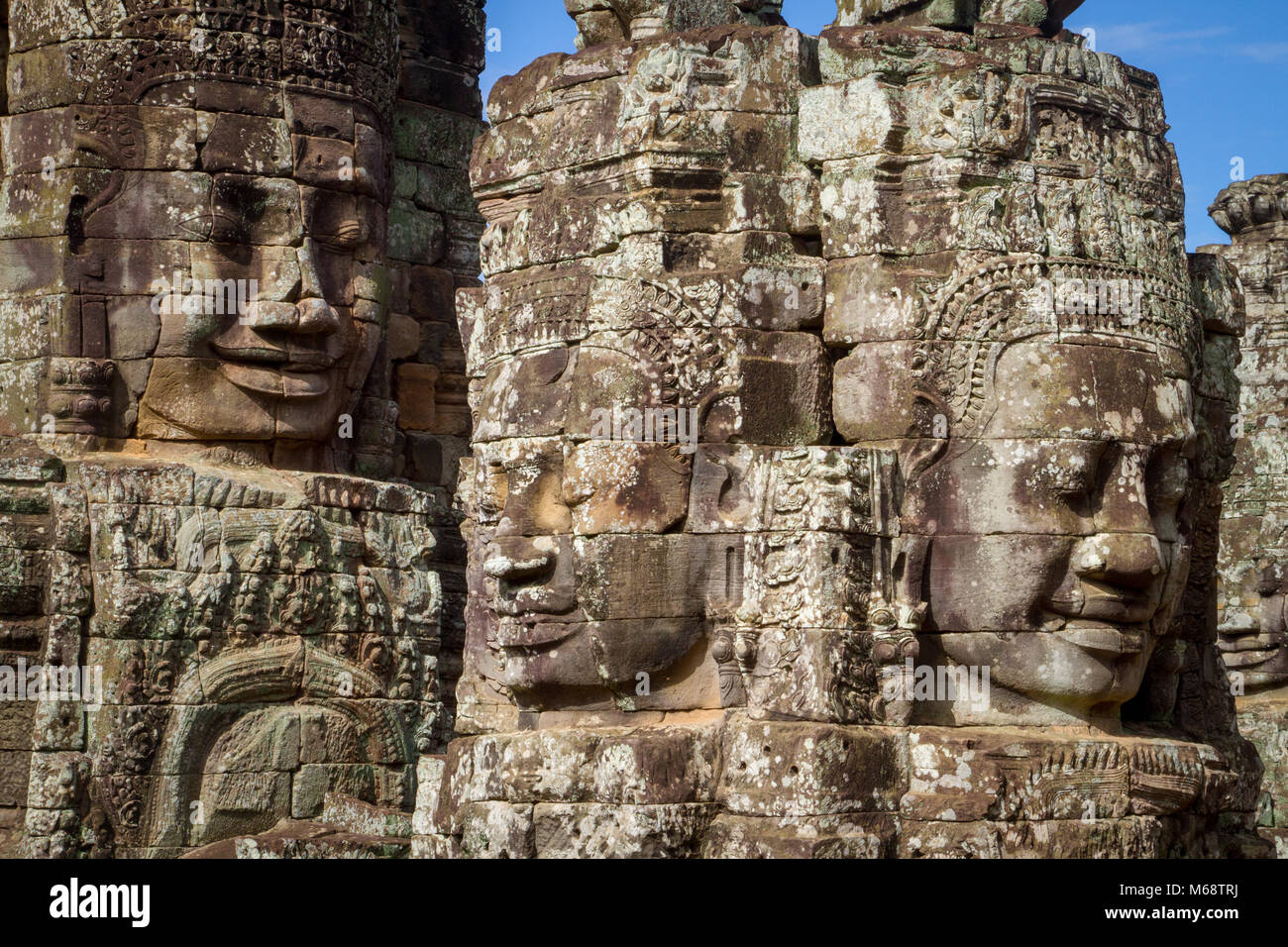 Facce scolpite nelle pareti e guglie di Angkor Wat, Cambogia. Foto Stock
