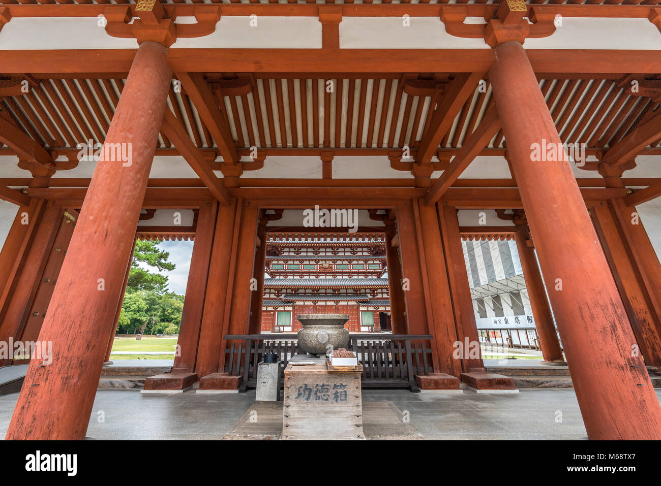 Nara - 25 Agosto 2017 : Yakushi-Ji tempio. Jokoro incenso bruciatore a Chumon gate, Kondo (sala principale) nel retro. Elencato come Patrimonio mondiale dell UNESCO Foto Stock