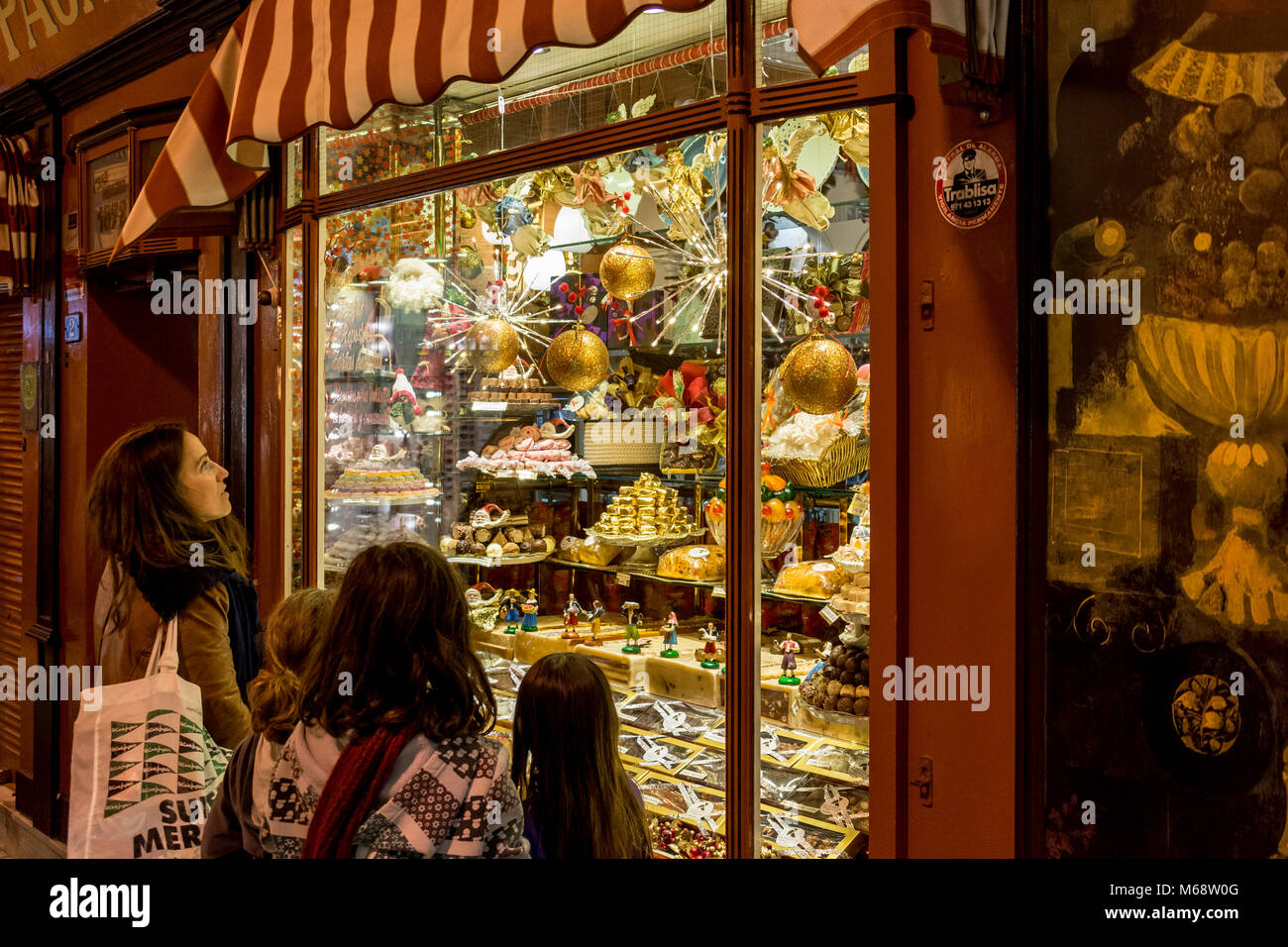 Auslage, Schaufenster eines Süßwarengeschäfts in Palma de Mallorca mit Passanten staunenden Foto Stock