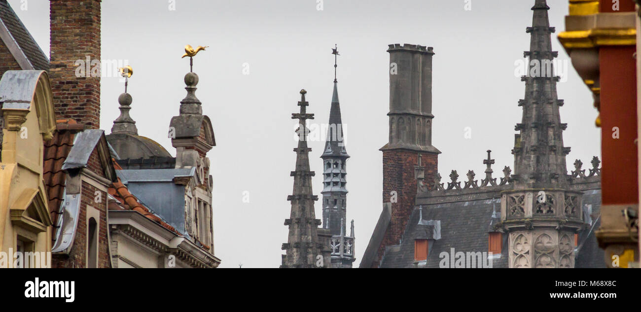 La chiesa gotica di pinnacoli e guglie adornano la skyline di architettonico di Bruges è antica e medievale città su una mattinata di ottobre. Foto Stock