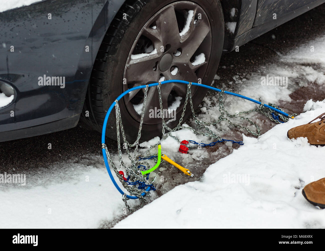 Catene da neve vicino al pneumatico autovettura in inverno sulla neve Foto Stock
