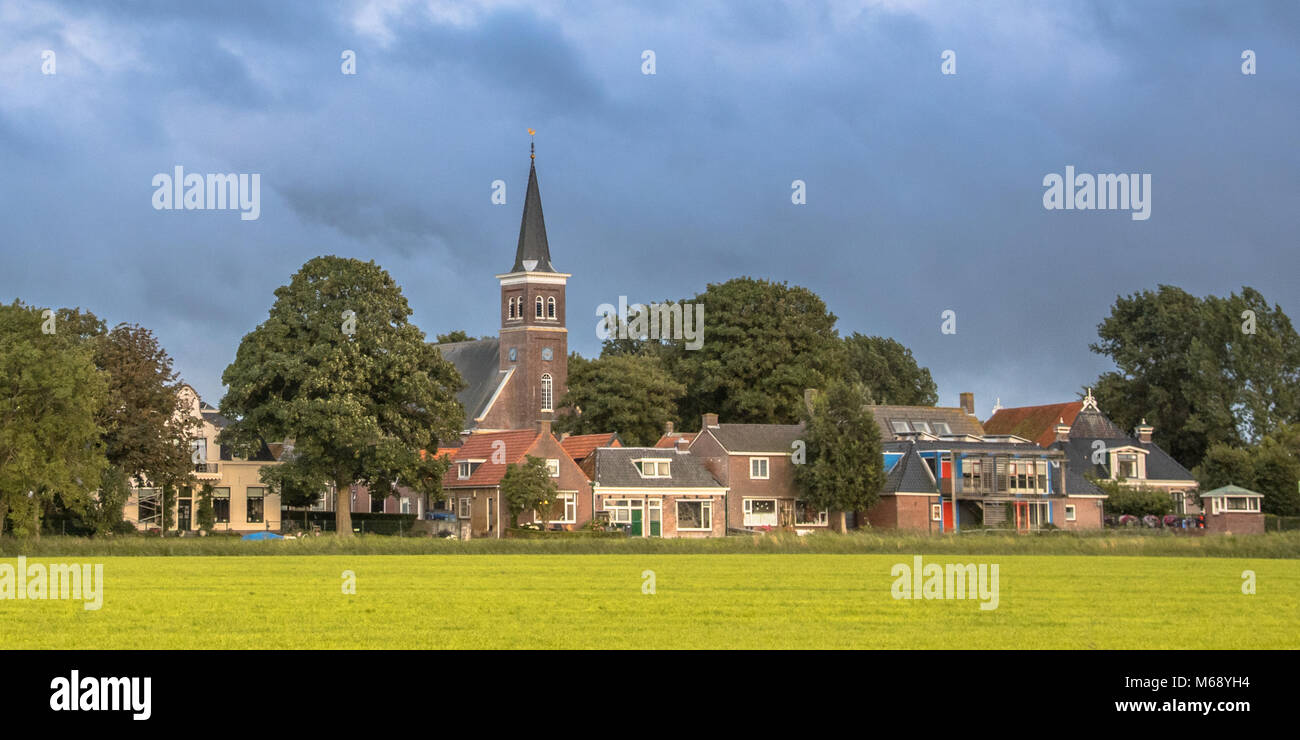 Skyline di chiesa un case olandesi di borgo agricolo di Tjerkwerd Frisia Paesi Bassi Foto Stock
