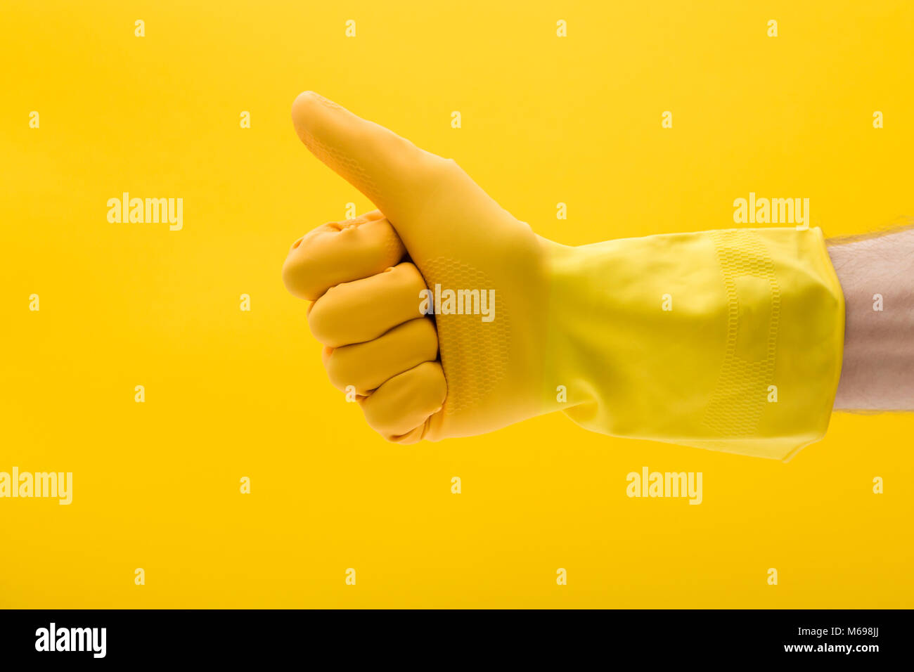 Pollice alzato la mano gesto di una mano in una gomma gialla guanto di pulizia Foto Stock