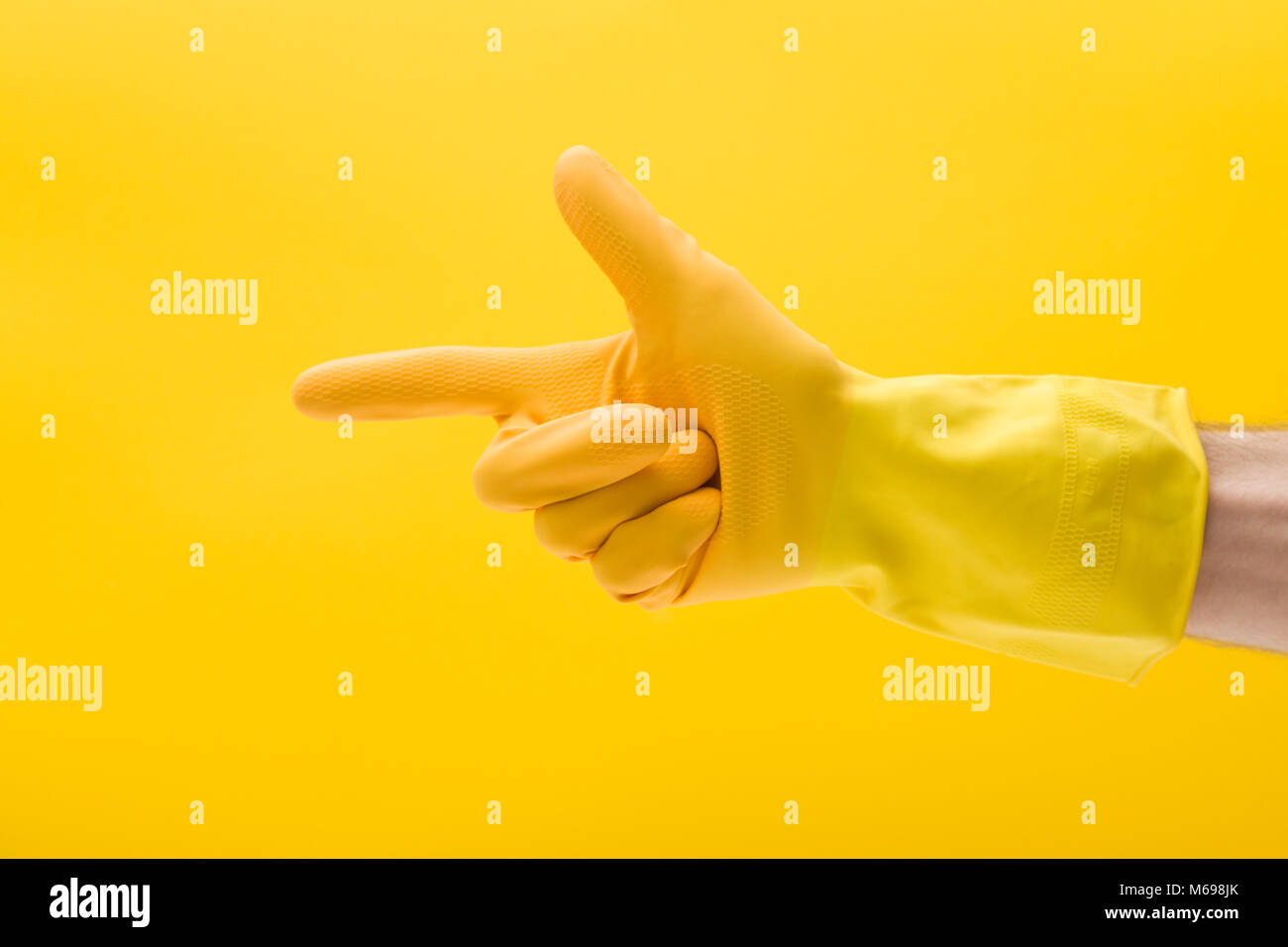 Mano di puntamento gesto di una mano in una gomma gialla guanto di pulizia Foto Stock
