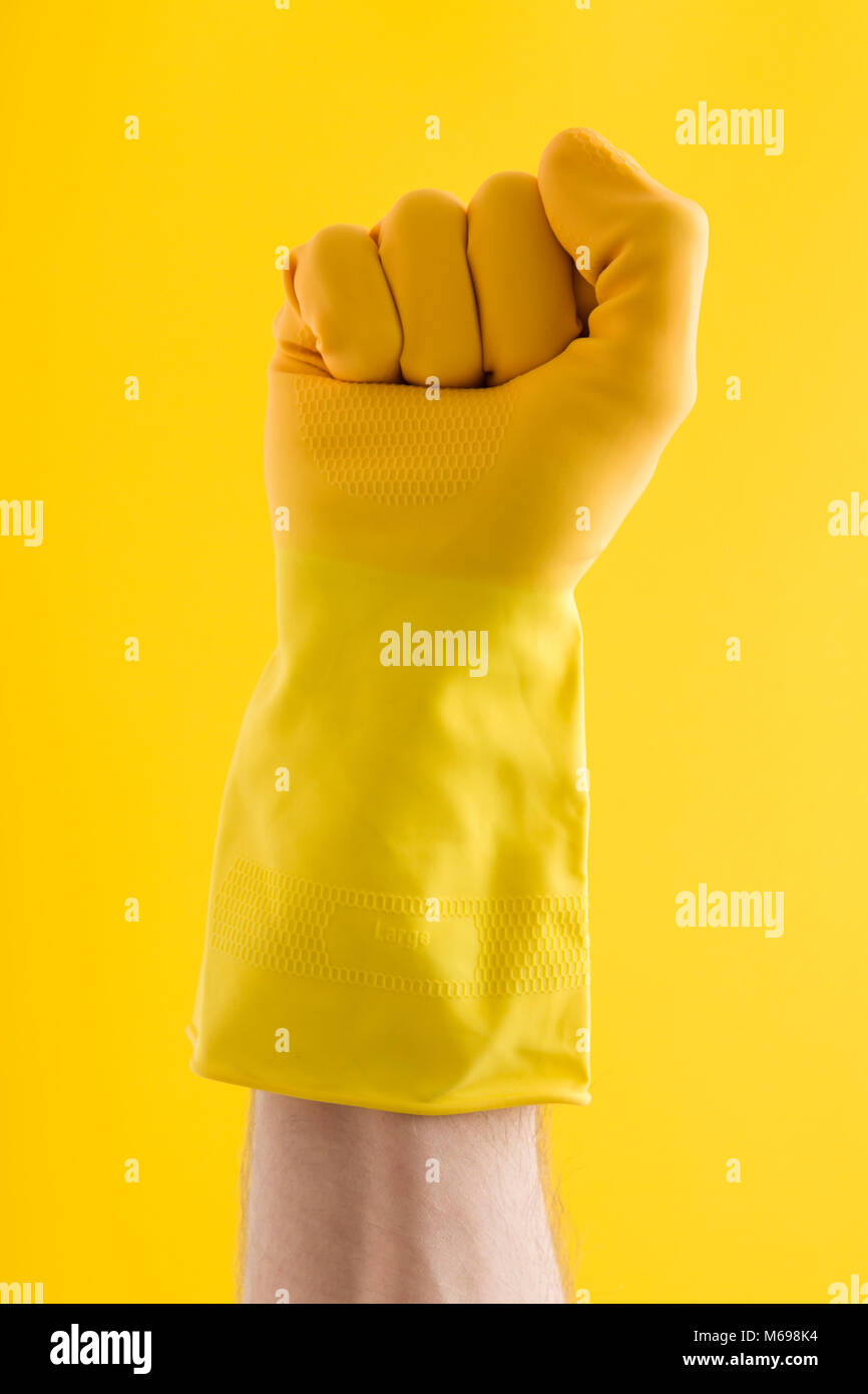 Pugno gesto a mano fatte da una mano in una gomma gialla guanto di pulizia Foto Stock