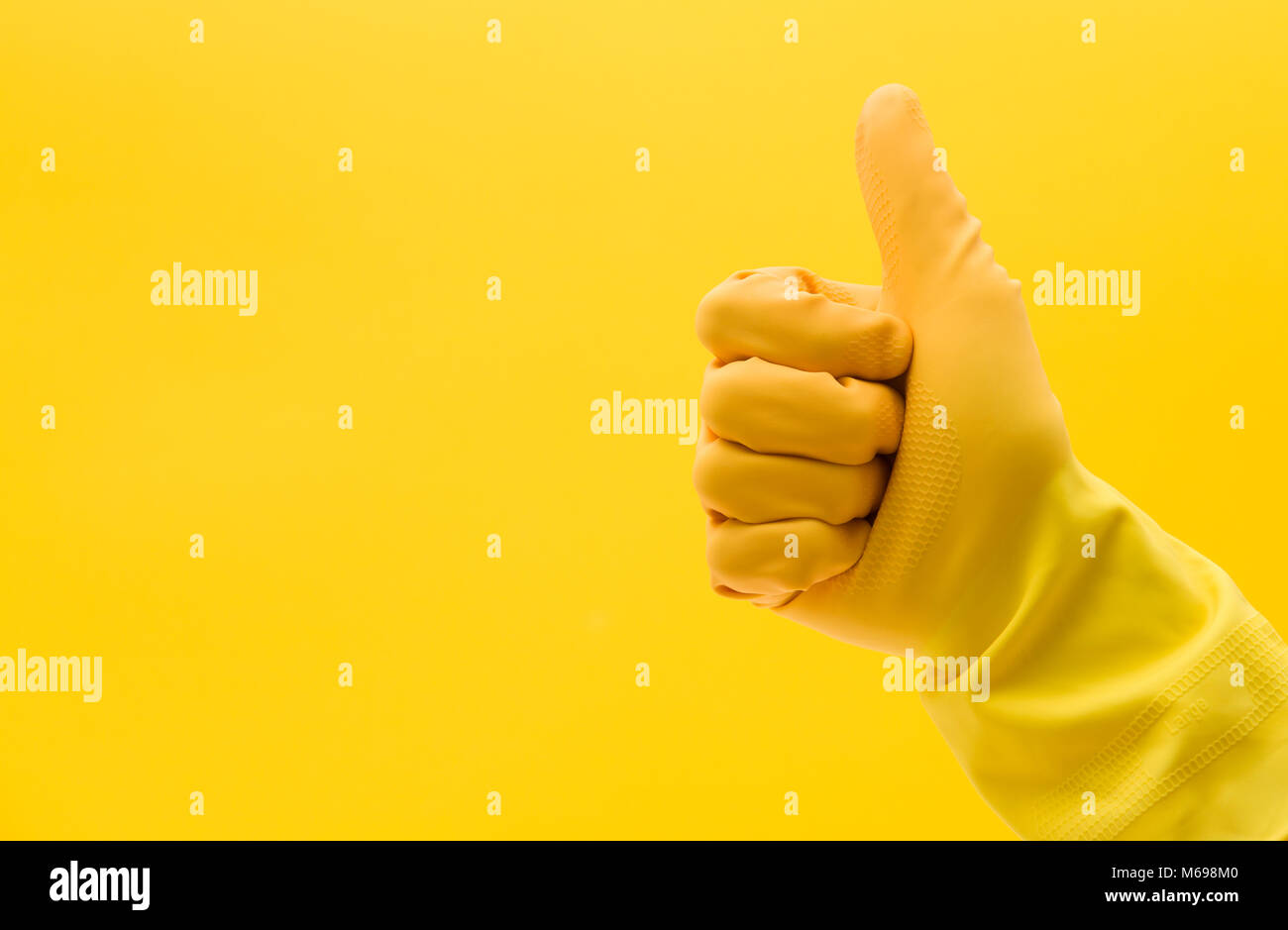Pollice alzato la mano gesto di una mano in una gomma gialla guanto di pulizia Foto Stock