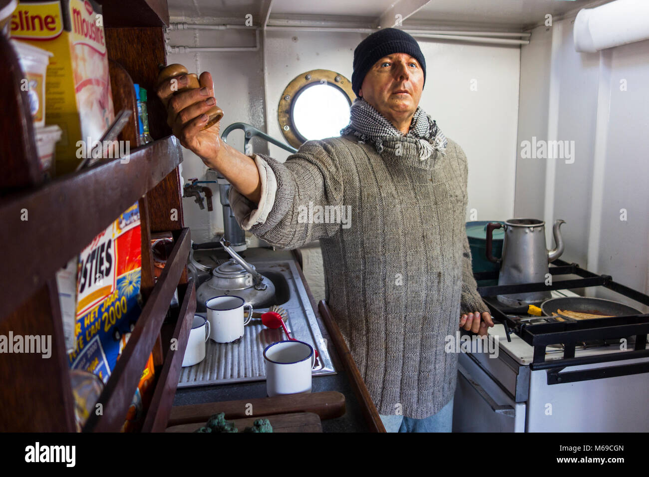 Membro di equipaggio cucinare la colazione nella cucina di bordo dell'ultimo Islanda trawler Amandine, rinnovato barca da pesca ora museo a Ostenda, Belgio Foto Stock
