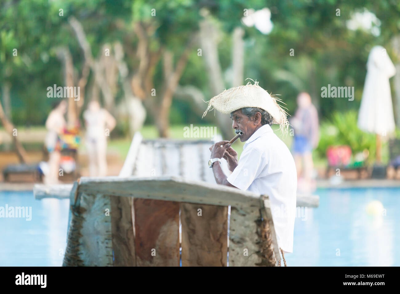 Ahungalla, Sri Lanka, Asia - un antico flauto nativo giocatore seduto sulla tradizionale longboat Foto Stock