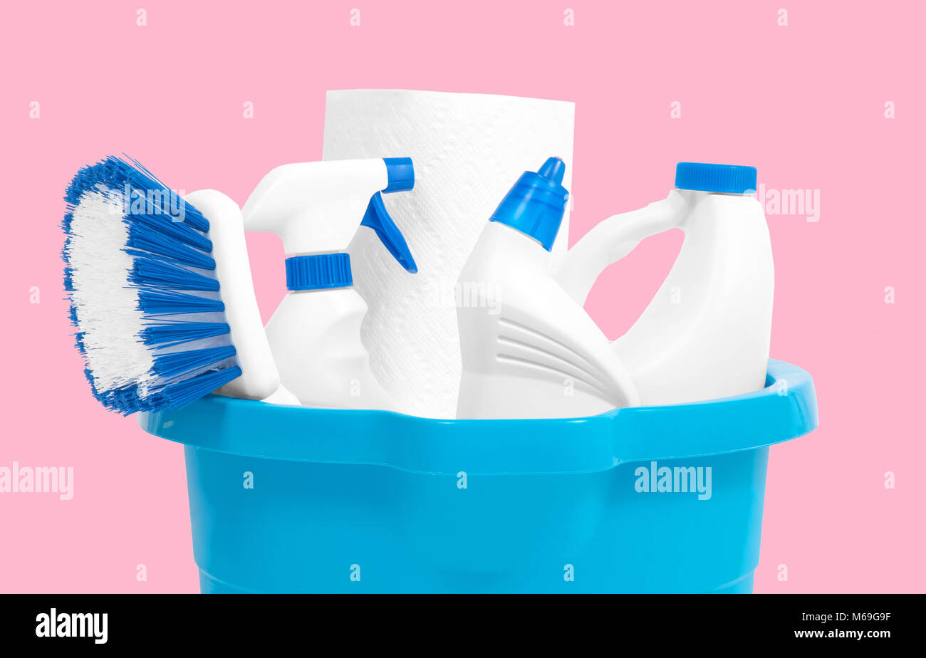 Varietà di prodotti di pulizia nella benna su sfondo color pastello. Strumenti di pulizia Foto Stock