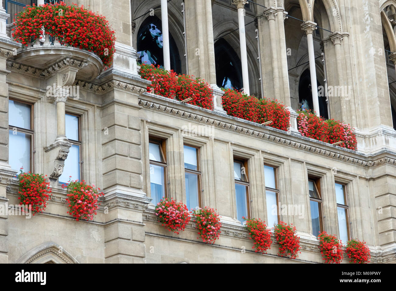 Windows nell'antica architettura degli edifici sono decorate con fiori. Foto Stock