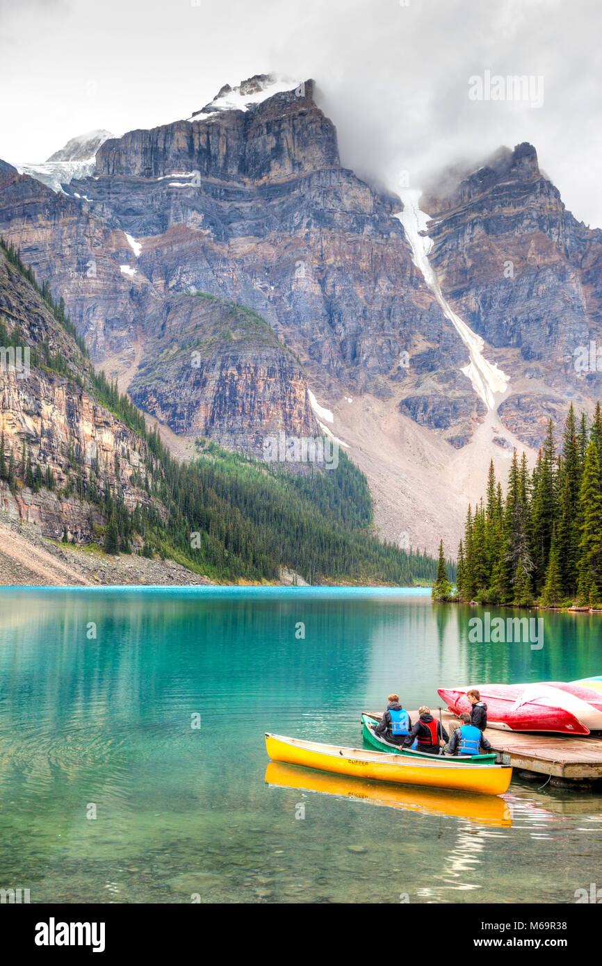 Il Lago Louise, Canada - 22 AGO 2014: canoisti di preparare la loro canoa sul Lago Moraine con nuvole scendono sulla Valle dei Dieci Picchi Foto Stock