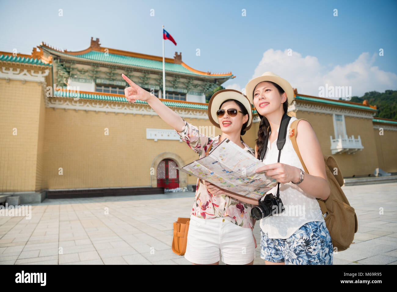 Turistica Locale rivolta che mostra il modo corretto per il Backpacker asiatica di venire qui da lei stessa. Sono entrambi di indossare cappelli e sorriso brillante. Foto Stock