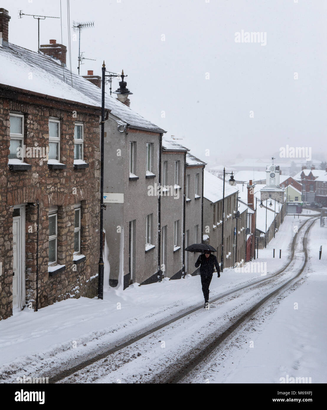 Armagh, Irlanda del Nord. 1 Mar, 2018. Un uomo cammina fino coperte di neve Dawson Street in Armagh City, troppo snowy a camminare lungo i sentieri che egli cammina sul altrimenti strada deserta. Credito: Darren McLoughlin/Alamy Live News Foto Stock