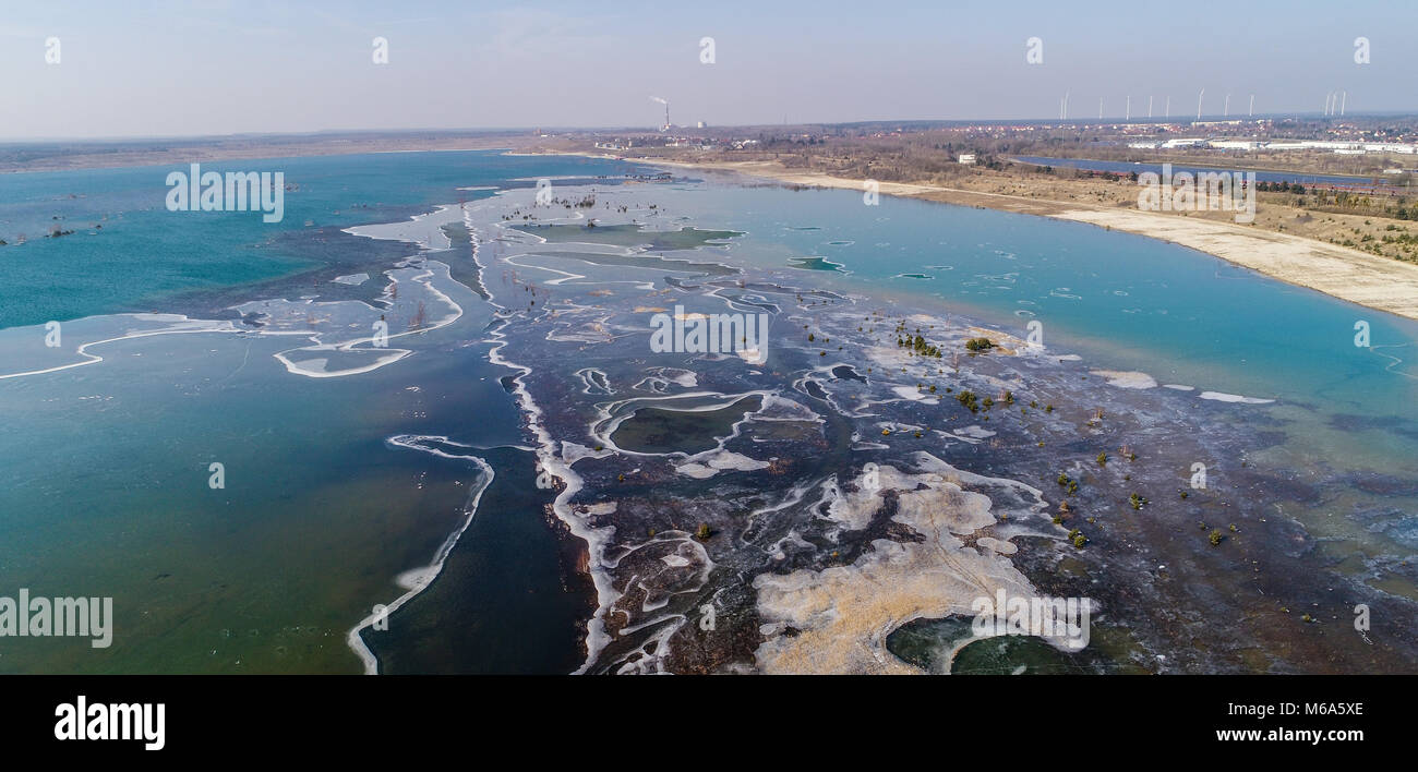 01 marzo 2018, Germania, Grossraeschen: il lago Grossraeschen è parzialmente ricoperto di ghiaccio (prese con drone). Per un paio di anni ormai la ex carbone marrone surfice mining è inondata e così è diventato parte del Lusatian Lake District. Qui, dove il carbone fossile bruno produzione determinato il paesaggio una volta, una nuova acqua paradiso con alcuni 14.000 ettari di superficie di acqua è di sviluppare da inondazioni ex surfice minings. Dieci dei più di 20 laghi sono per essere aperta da canali navigabili. Foto: Patrick Pleul/dpa-Zentralbild/ZB Foto Stock