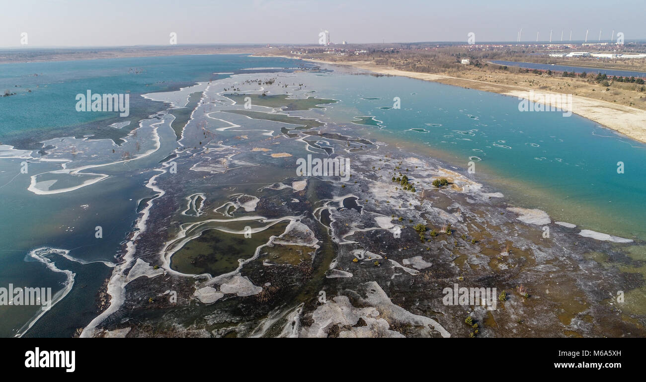 01 marzo 2018, Germania, Grossraeschen: il lago Grossraeschen è parzialmente ricoperto di ghiaccio (prese con drone). Per un paio di anni ormai la ex carbone marrone surfice mining è inondata e così è diventato parte del Lusatian Lake District. Qui, dove il carbone fossile bruno produzione determinato il paesaggio una volta, una nuova acqua paradiso con alcuni 14.000 ettari di superficie di acqua è di sviluppare da inondazioni ex surfice minings. Dieci dei più di 20 laghi sono per essere aperta da canali navigabili. Foto: Patrick Pleul/dpa-Zentralbild/ZB Foto Stock