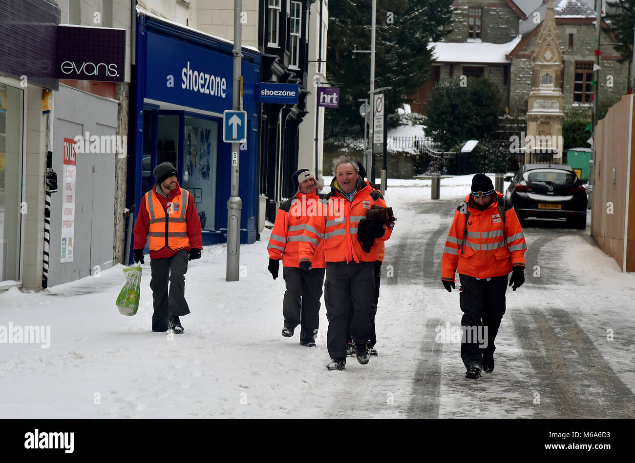 Le immagini mostrano la scena di Bridgend, nel Galles del Sud, questo venerdì dopo la tempesta Emma a sinistra alcuni cm di neve nella sua scia. Bridgend consiglio i lavoratori sono raffigurati lo sgombero neve e ghiaccio off marciapiedi e passaggi pedonali. Royal Mail personale è raffigurato il ritorno a casa non sono in grado di lavorare a causa di avverse condizioni atmosferiche, sono raffigurate nella strada commerciale del centro città. Una macchina viene spinta attraverso la neve in Nolton Street nel centro di Bridgend. Un veicolo 4x4 fa il suo modo attraverso la strada commerciale.. Un lone shopper fa il suo modo di ASDA. Un uomo braves il meteo indossare pantaloni corti durante la rimozione di neve. Foto Stock