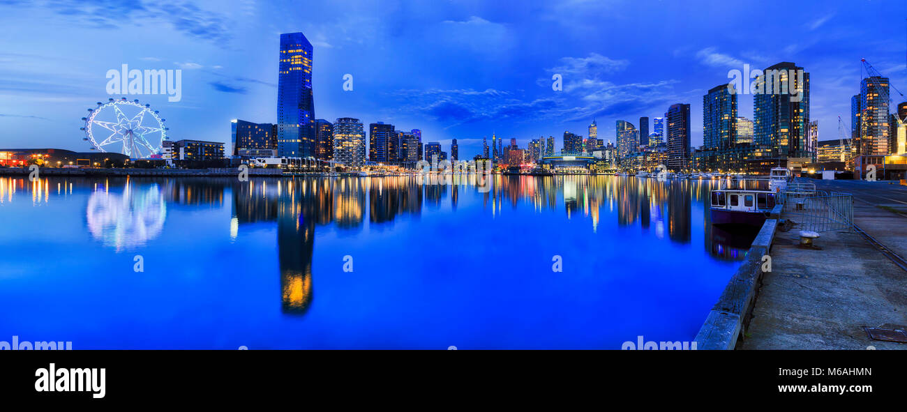 Blue panorama al tramonto sulla Docklands a Melbourne quando ubran moderna architettura riflette ancora in acque del fiume Yarra. Foto Stock