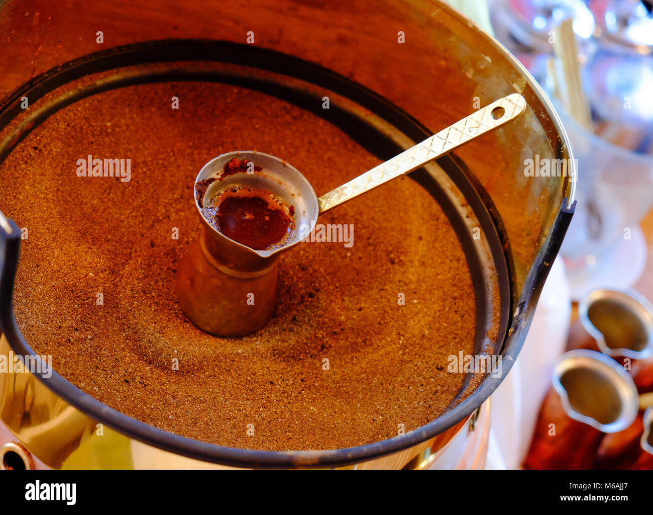 Rendendo tradizionale greco / turco caffè nero sulla sabbia Foto Stock