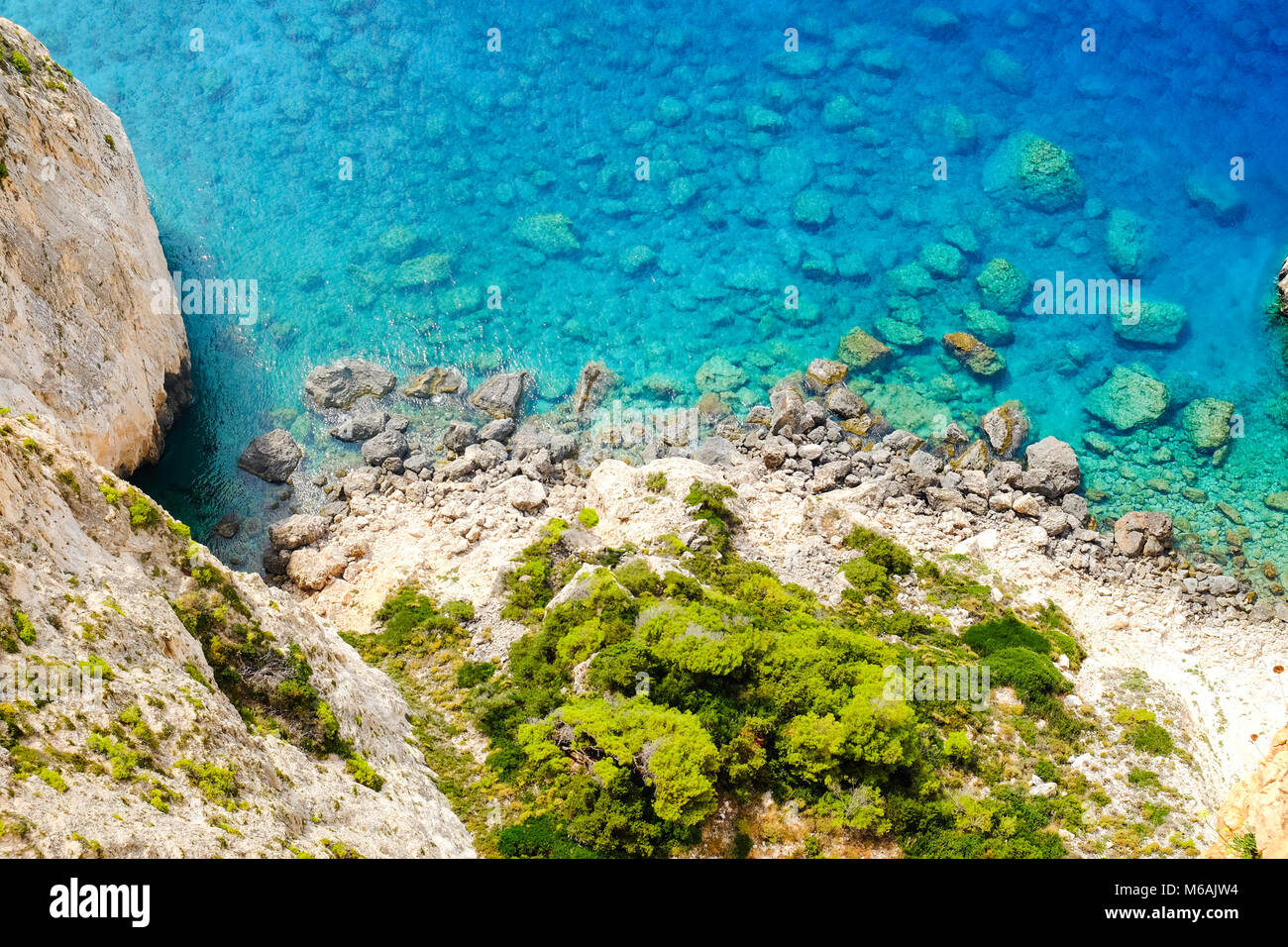 Spiaggia rocciosa con acque blu e cristalline sull'isola di Zante, Grecia Foto Stock