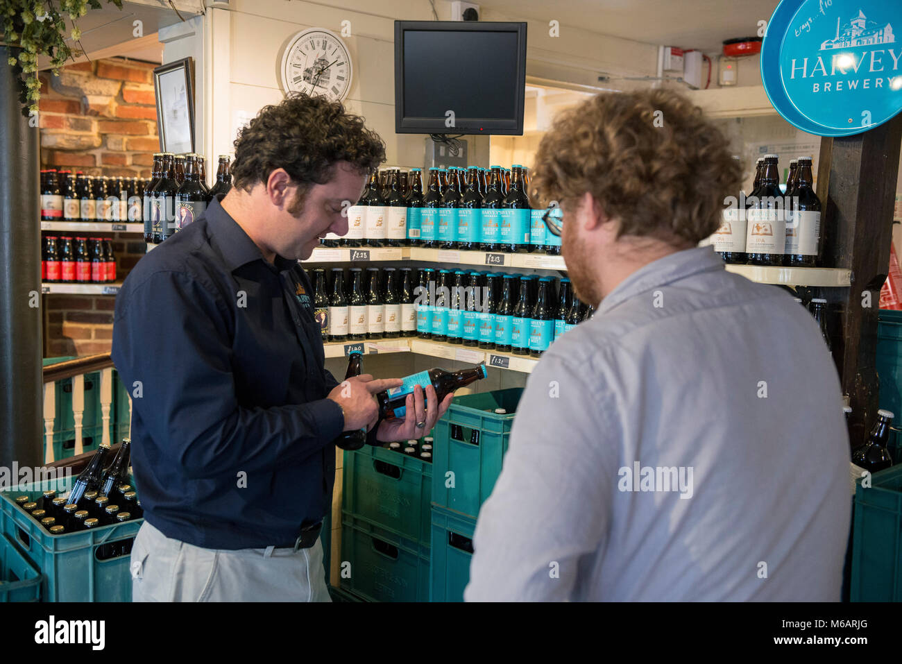 Il manager dell'Harvey's Brewery real ale shop di Lewes, East Sussex. Foto Stock