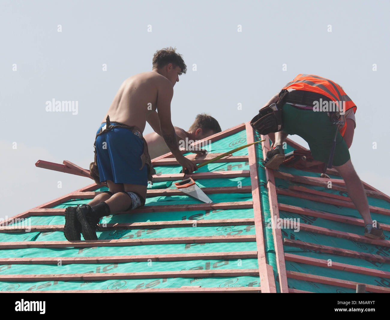 Coperture gli appaltatori che lavorano sul tetto della nuova build Hopkins case di sviluppo, NORFOLK Foto Stock