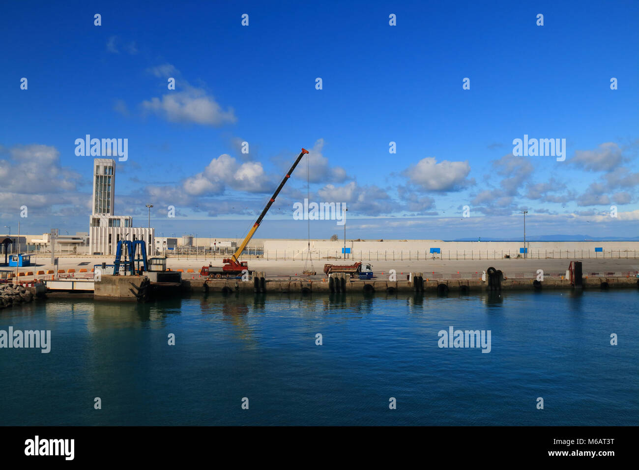 Gli uomini con macchine pesanti lavorando al porto Foto Stock