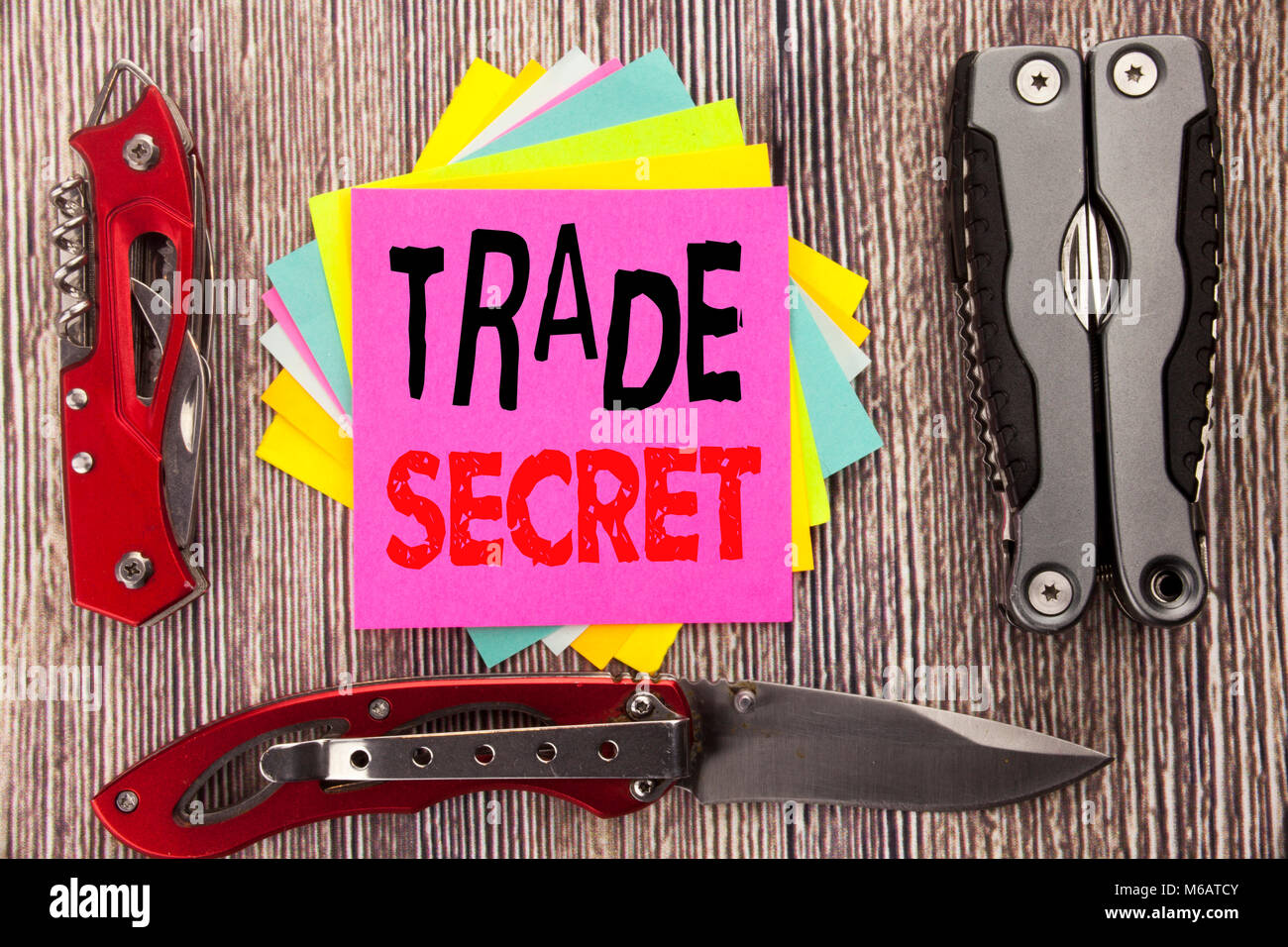 La scrittura di un testo che mostra il segreto commerciale. Il concetto di business per la protezione dei dati scritti su sfondo di legno con coltellino tascabile con uno spazio Foto Stock