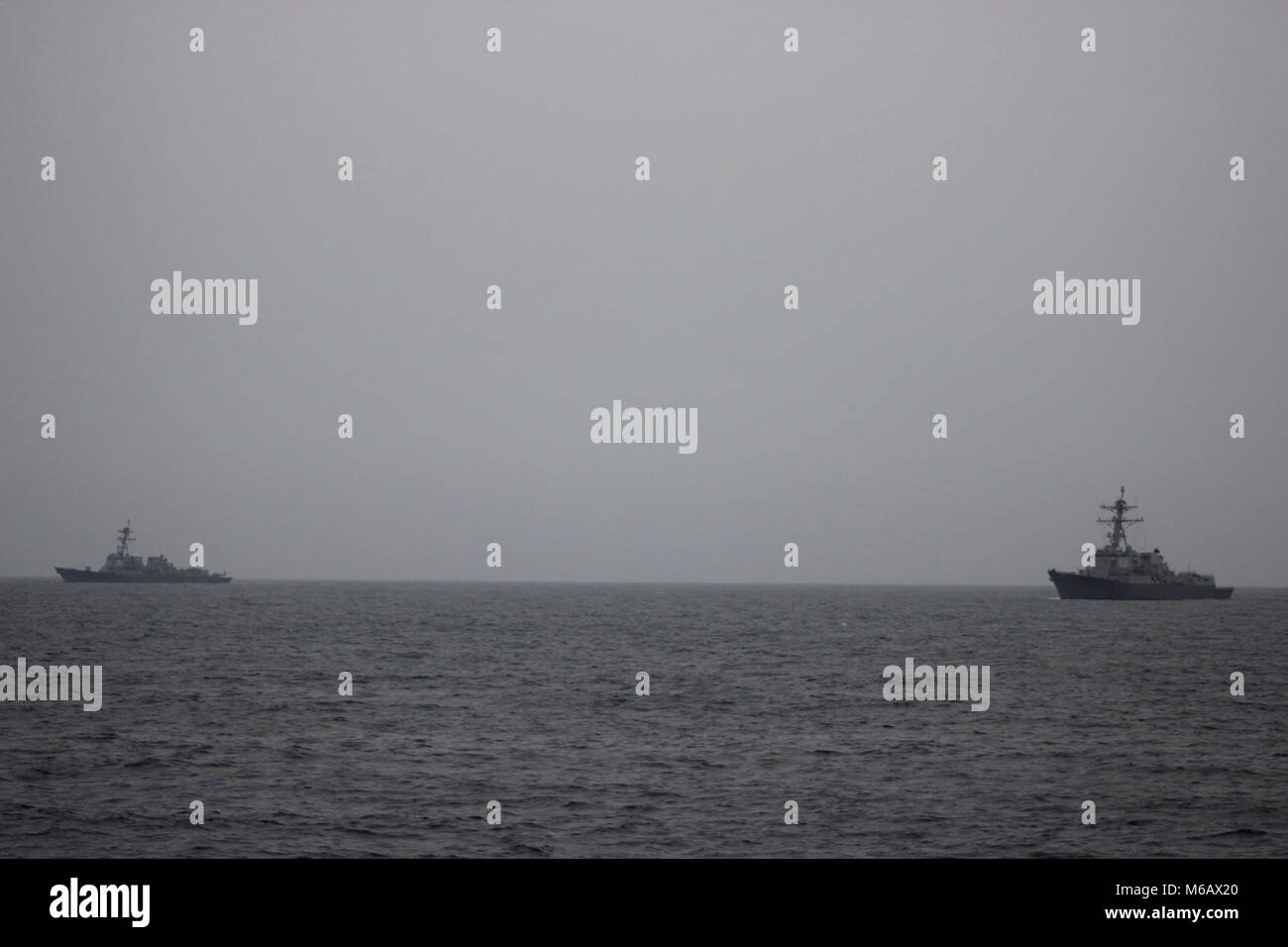 Stati Uniti 5TH FLOTTA AREA DI OPERAZIONI (feb. 25, 2018) (da sinistra a destra) USS Halsey (DDG 97) e USS Sampson (DDG 102) sono visibili in lontananza durante un trasferimento di passeggeri con USS Lewis B. estrattore (ESB 3). La expeditionary base mobile supporta la piattaforma navale Forza anfibia, Task Force 51/5th Marine Expeditionary Brigade diverse missioni che includono la risposta alle crisi, airborne miniera contromisure contro la pirateria operazioni, le operazioni di sicurezza marittima e di aiuti umanitari/Disaster Relief missioni pur consentendo TF 51/5 per estendere la sua presenza expeditionary in tutto il mondo più regioni di volatili. Foto Stock