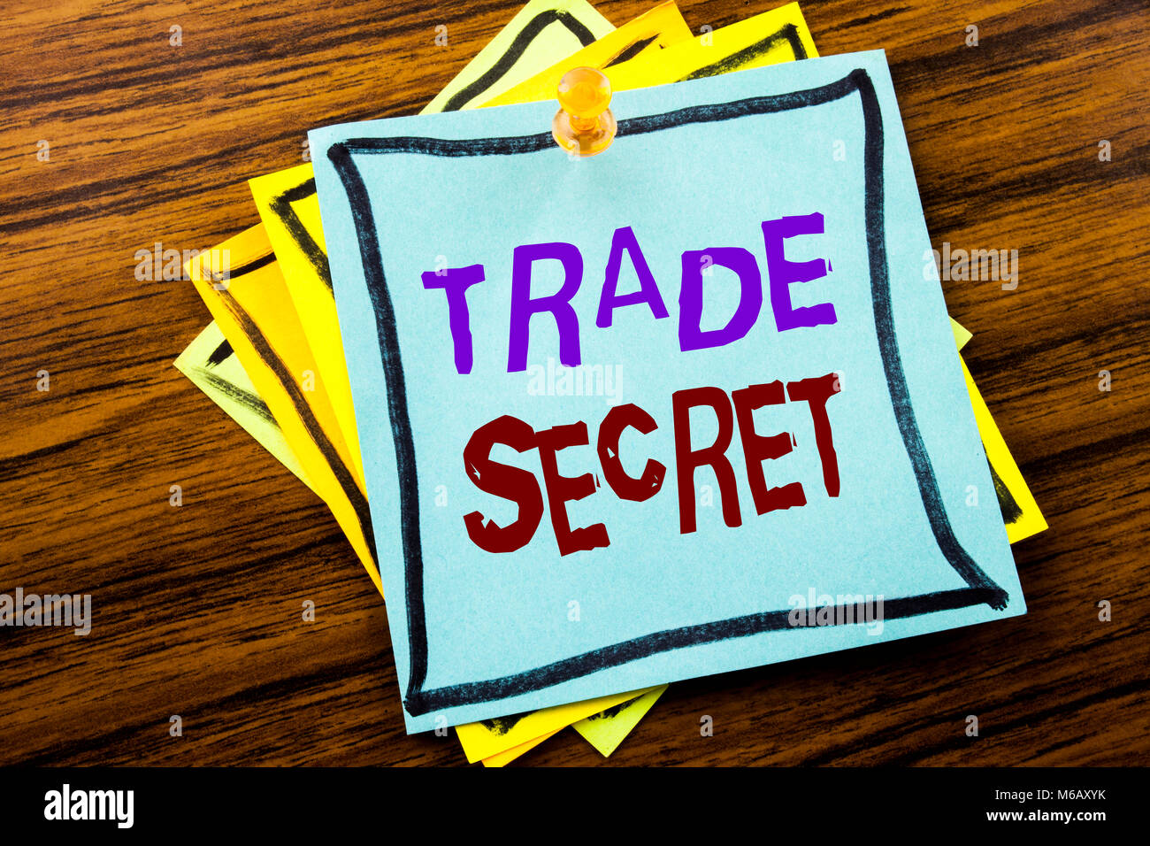 La scrittura di un testo che mostra il segreto commerciale. Il concetto di business per la protezione dei dati scritti su una nota adesiva carta su sfondo di legno. Foto Stock