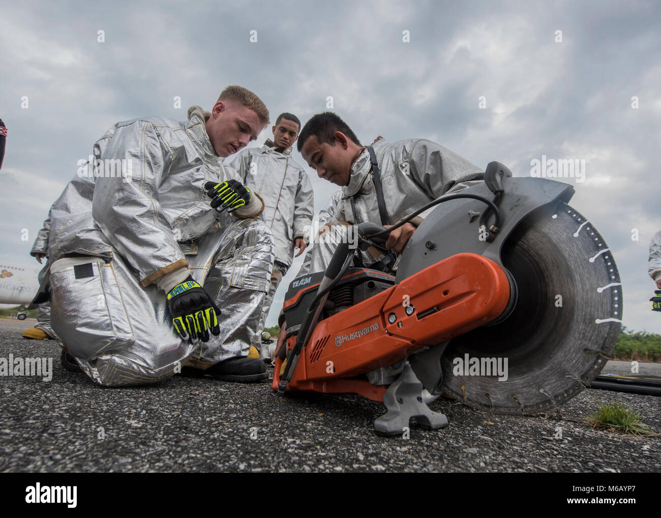 Stati Uniti Marine Corps Lance Cpl. Joshua liberato un vigile del fuoco expeditionary con Marine Wing Support Squadron 172 da Kansas City, Mo., mostra il Royal Thai Navy seaman Jehalee Samaair, firefigher dalla provincia di Yala, Thailandia, come far funzionare un K-12 powersaw Feb 20, 2018 durante il velivolo formazione di estrazione a U Tapao-Aeroporto internazionale, divieto di Distretto Chang, provincia di Rayong, Thailandia. La formazione è stata condotta come parte di esercizio Cobra Gold 2018. Dopo la formazione di estrazione, l'estinzione combinato team ha condotto un live masterizzare per simulare un incidente aereo. La formazione bilaterale attivata pompiere Foto Stock