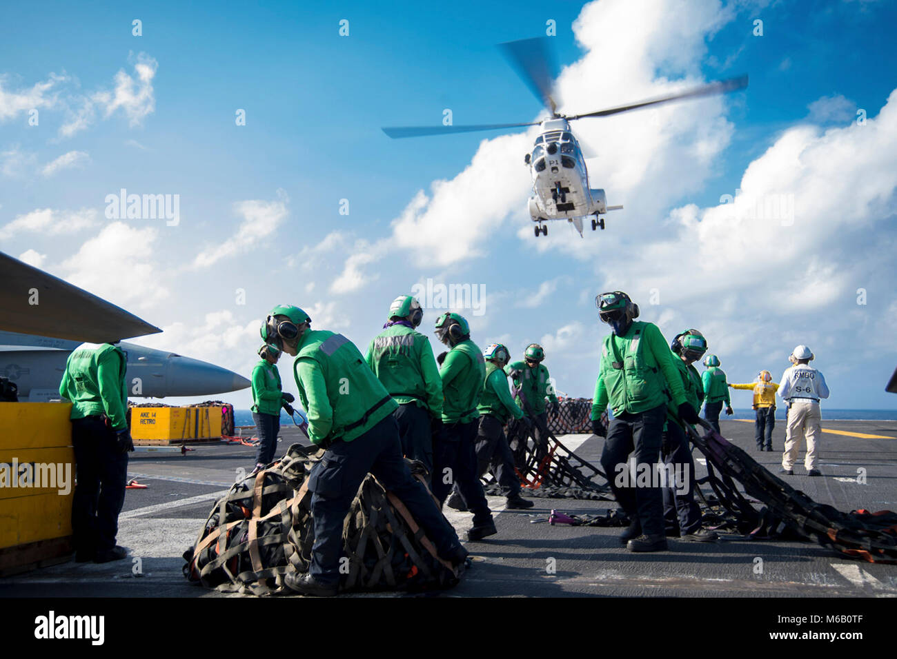 Sul mare del sud della Cina (feb. 26, 2018) Una SA-330 Puma elicottero assegnati ai militari di comando Sealift Lewis e Clark-class di carichi secchi e munizioni nave USNS Cesar Chavez (T-AKE 14) scende di un carico durante un rifornimento verticale in mare sul ponte di volo dell'Nimitz-class portaerei USS Carl Vinson (CVN 70). La Carl Vinson Carrier Strike gruppo è operativo nel Pacifico occidentale come parte di una distribuzione programmata. (U.S. Navy Foto Stock