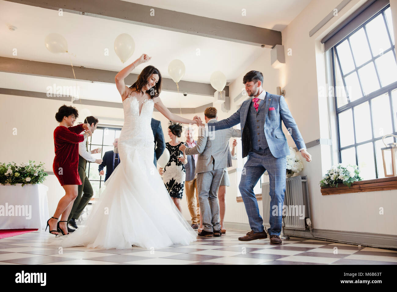 Coppia di novelli sposi sono godendo di ballare con tutti i loro ospiti il giorno delle nozze. Foto Stock