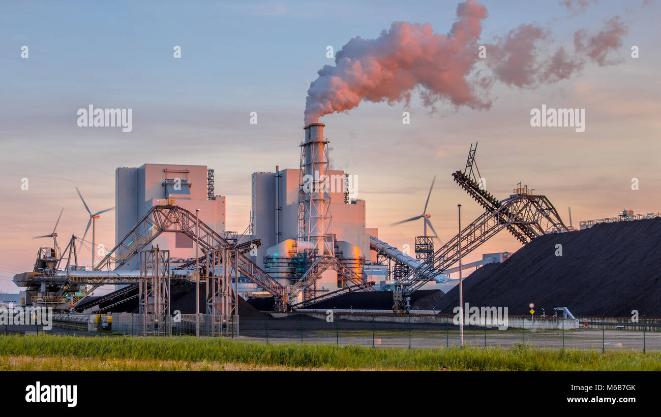 Pesanti industriali del carbone energia elettrica impianto con tubi di fumo e in arancione luce del sole di setting Foto Stock