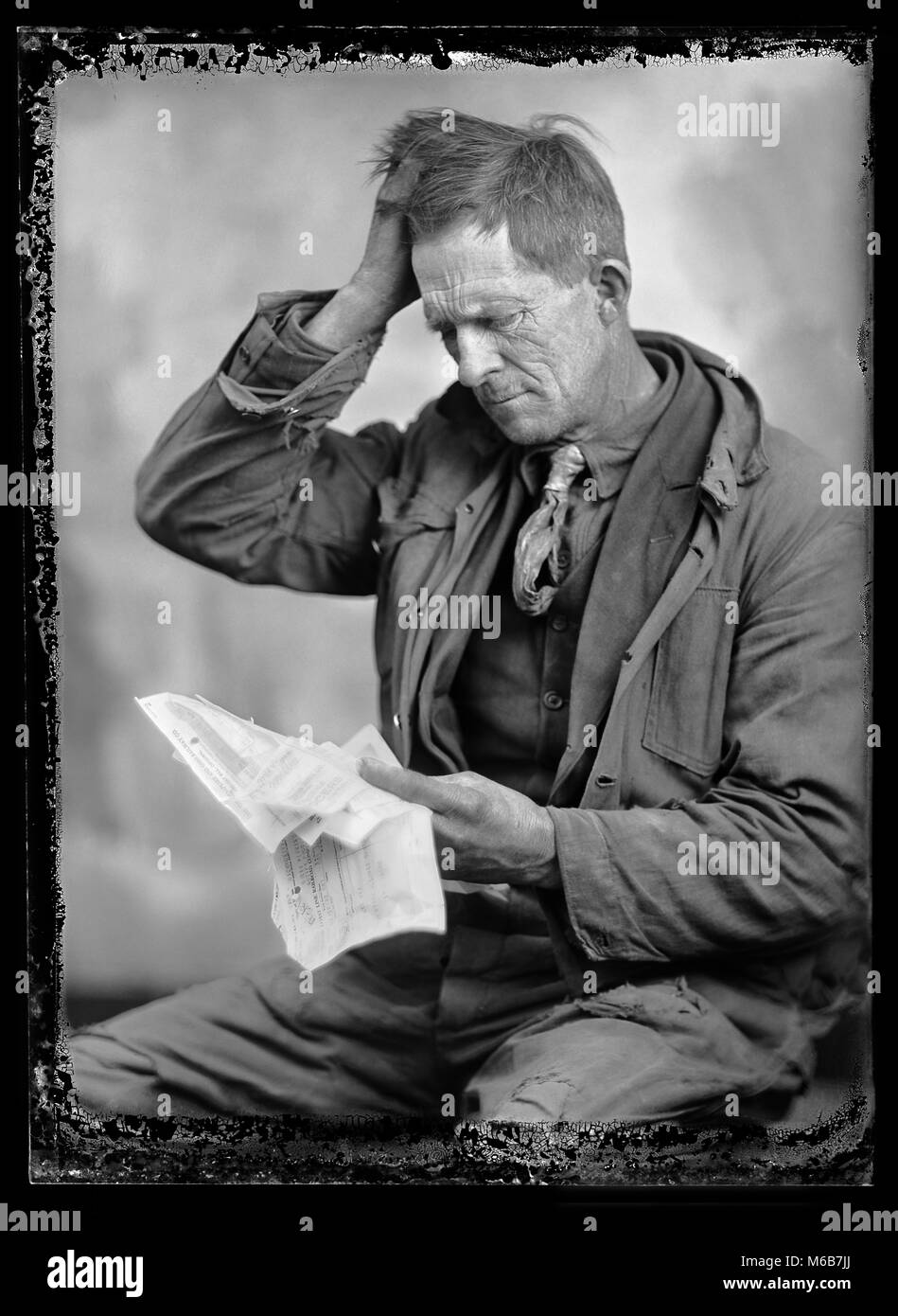 Un uomo preoccupato esamina la sua bolletta, 1924. immagine da 5x7 pollici negativo di vetro. Foto Stock