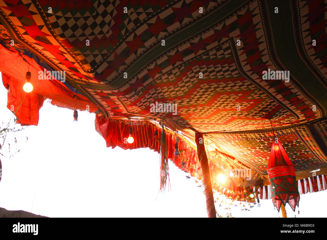 Deserto tradizionale tenda realizzata di coloratissimi modellato tessuti etnici su pali in legno e decorate con luci e altri gadget, Rajastan, India. Foto Stock