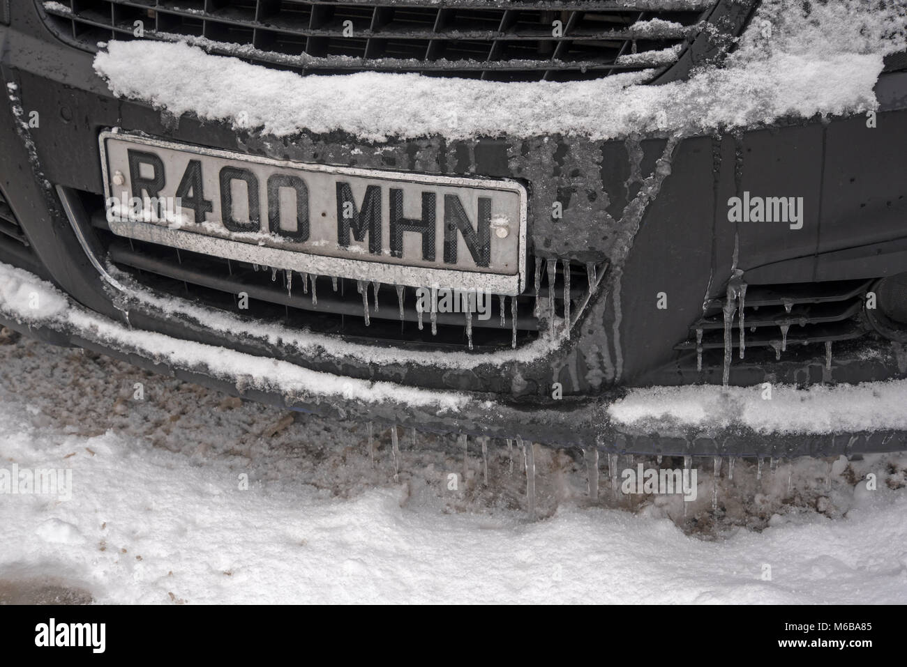 Ghiaccioli appesi ad un auto la piastra di registrazione. Foto Stock