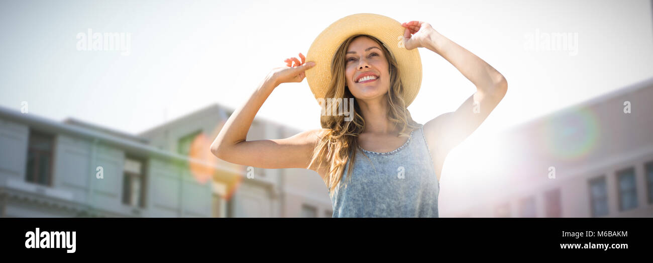 Immagine composita del ritratto di una donna di toccare il suo cappello di paglia Foto Stock