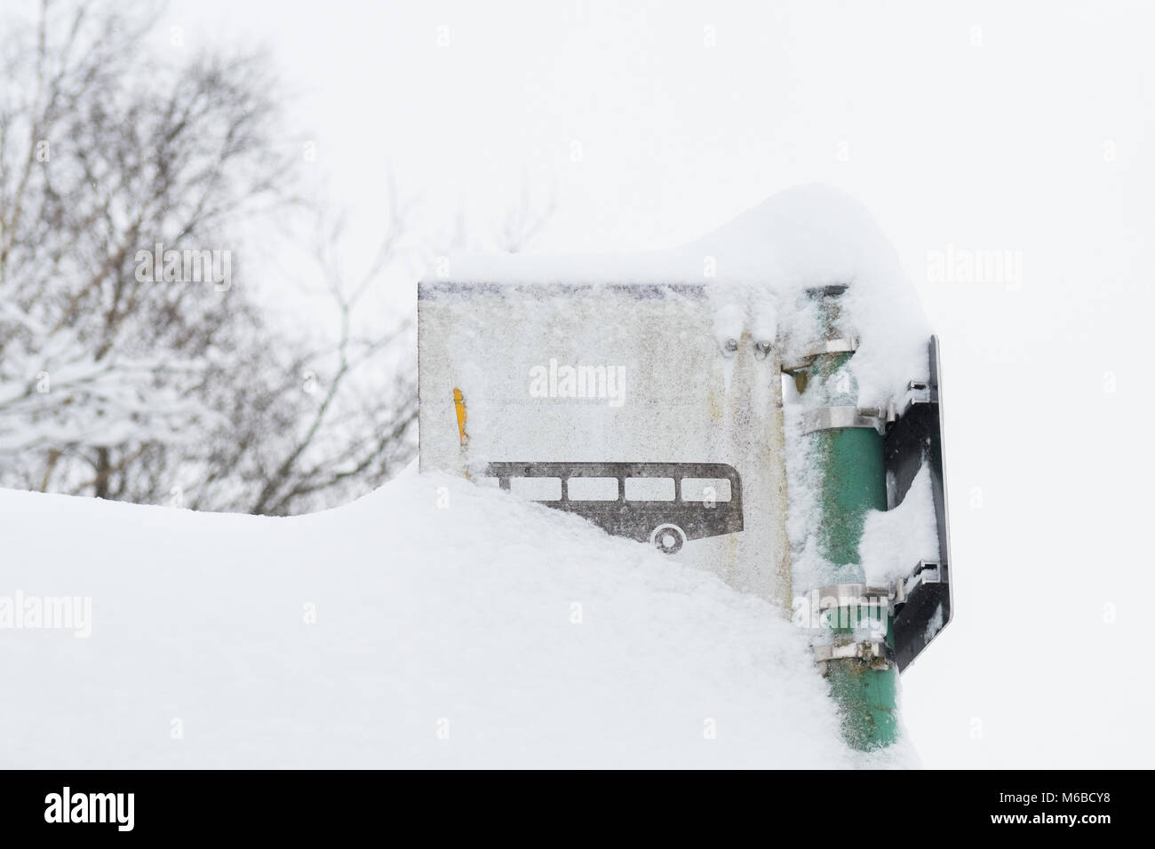 Fermata bus segno ricoperta di neve - trasporto pubblico nel concetto di inverno - Scozia, Regno Unito Foto Stock