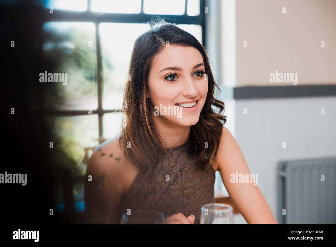 Giovani donne sta godendo di se stessa in corrispondenza di un evento sociale con gli amici. Essi sono di bere vino. Foto Stock