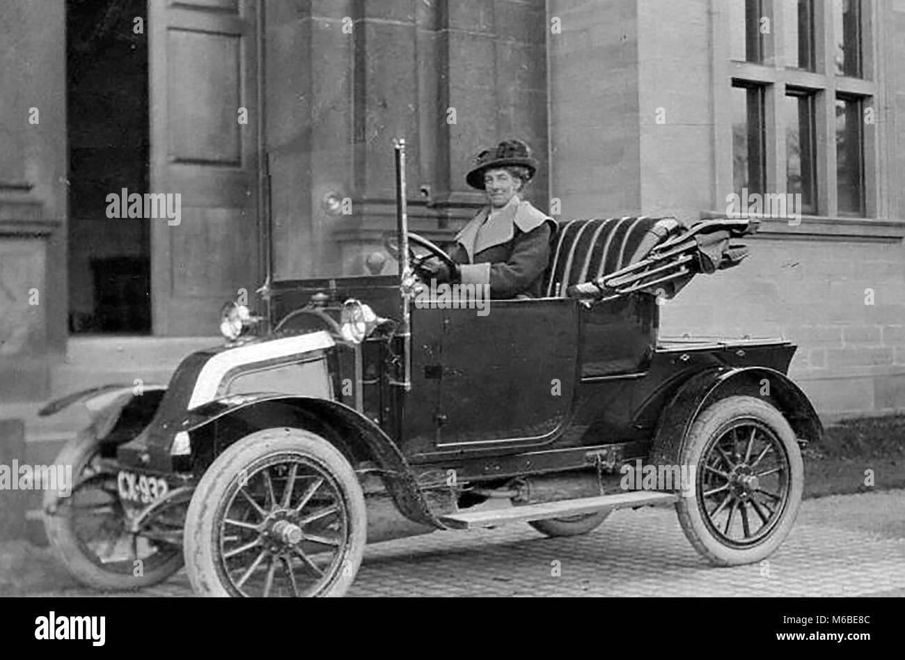 Una foto di una sommità aperta vintage convertibile inizio auto con una donna conducente Foto Stock