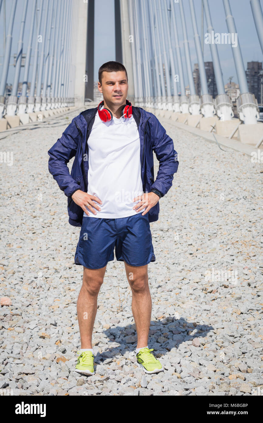 Ritratto di uno sportivo fitness runner con le cuffie. Uno stile di vita sano e concetti di allenamento Foto Stock