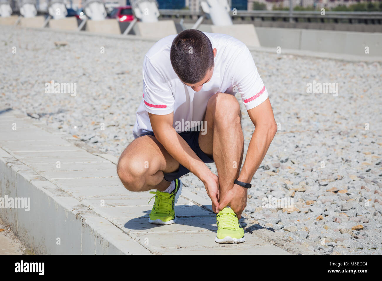 Esecuzione di atleta sentire dolore dopo avente il suo ginocchio infortunato. Incidente sulla via di corsa durante l'esercizio mattutino. Sport i concetti di incidente Foto Stock