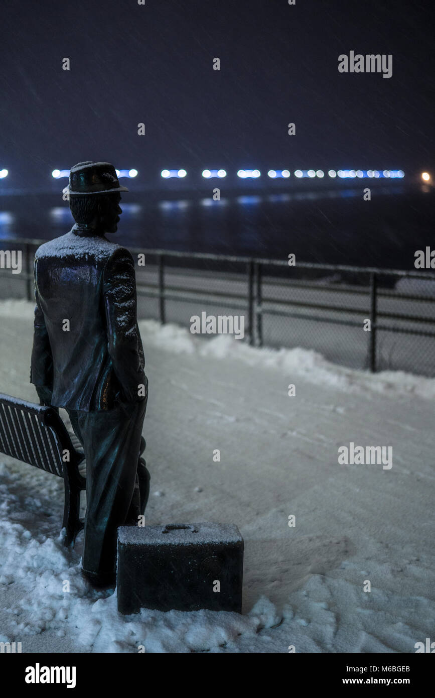 Uomo in attesa del treno in tempesta di neve. Foto Stock