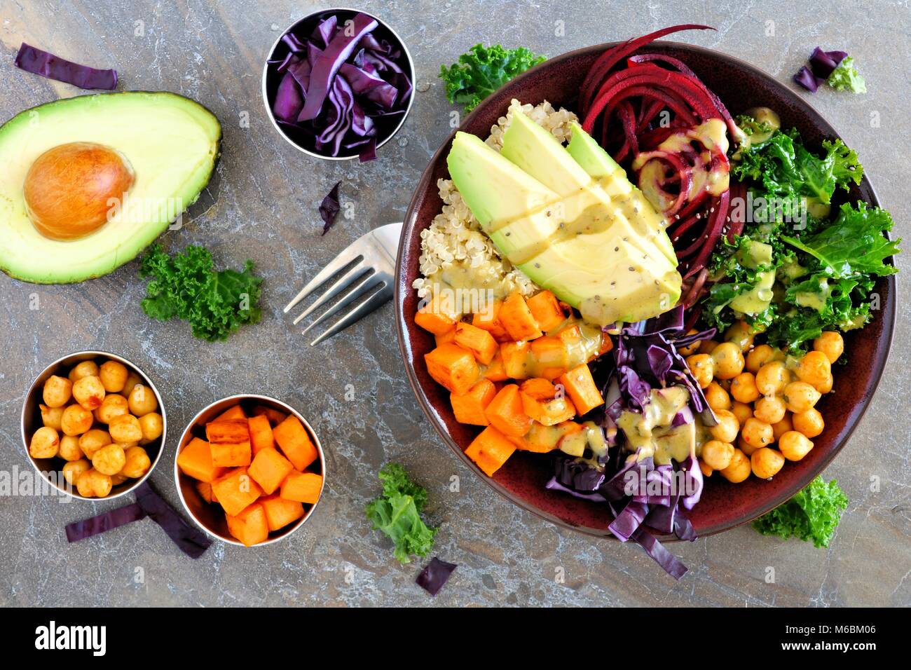 Ciotola di Buddha con la quinoa, avocado, ceci, le verdure su una pietra scura sullo sfondo, mangiare sano concetto. Tettuccio di scena. Foto Stock