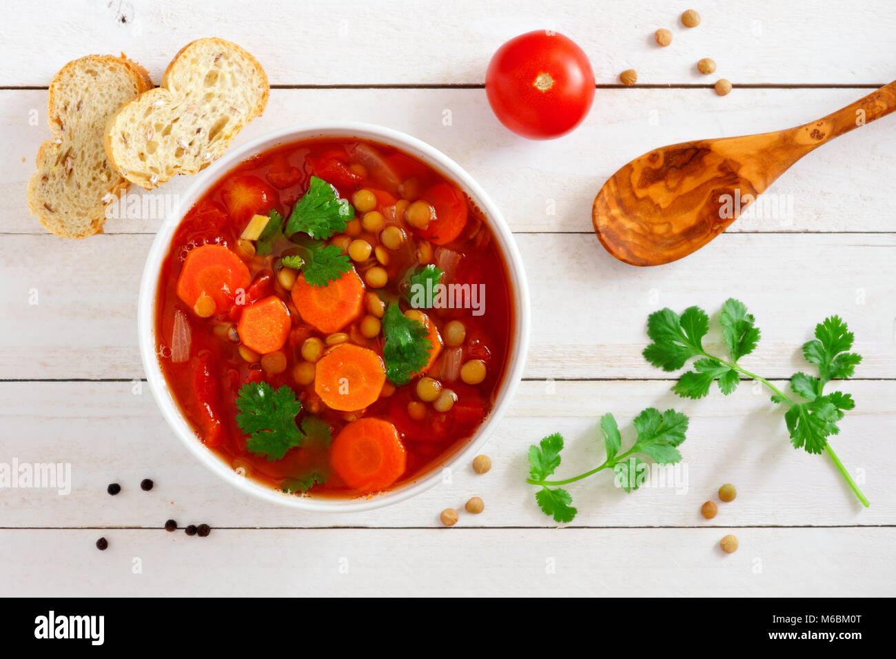 In casa di pomodoro, zuppa di lenticchie, sopra Scena su un bianco sullo sfondo di legno Foto Stock