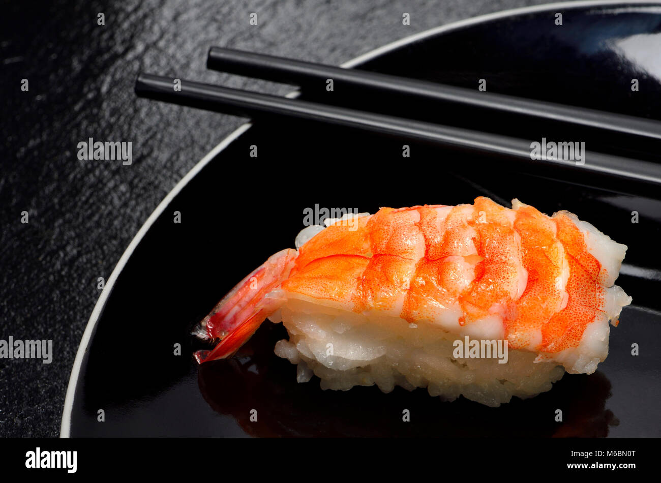 Sushi su una piastra nera: Nigiri (pesce serviti sulla sommità del riso) e bastoncini Foto Stock