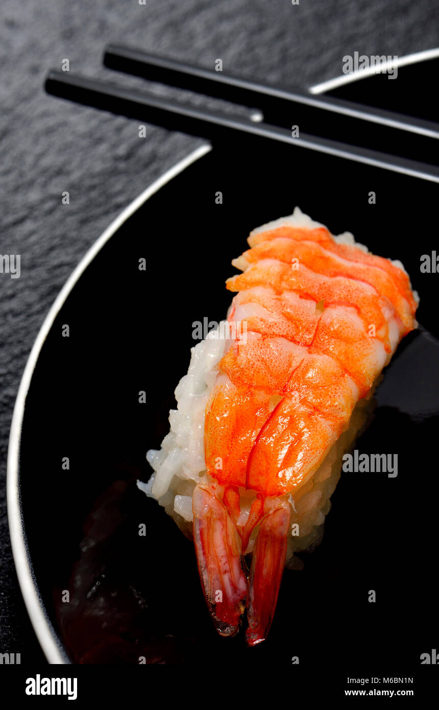 Sushi su una piastra nera: Nigiri (pesce serviti sulla sommità del riso) e bastoncini Foto Stock